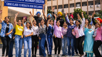 Students celebrating after CBSE Class 12 Results 2026 declaration outside a school campus with victory signs and joyful expressions.