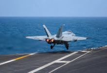 US fighter jet taking off from an aircraft carrier over the sea amid rising tensions in the Middle East.