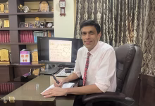 Medical professional seated in a modern clinic office at Dr. Yande's Speciality Daycare Centre, Pune, with awards, certificates, and healthcare achievements displayed in the background.