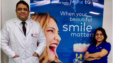 Dental specialists at Jehangir Oracare Dental Care Centre Pune standing beside a smile care display, showcasing advanced dental treatments and expert oral healthcare services.