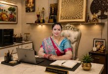 Shweeta Oberoi, renowned Vedic astrologer and spiritual guide, seated in her elegant office with a laptop, notebook, awards, and sacred décor, representing astrology, numerology, Vastu, and palmistry services.
