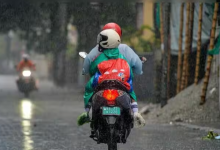 People ride a motorcycle during heavy rainfall as the India Meteorological Department (IMD) issues a heavy rain alert for multiple states across India.
