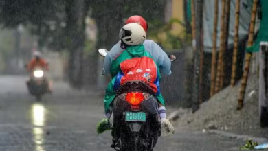 People ride a motorcycle during heavy rainfall as the India Meteorological Department (IMD) issues a heavy rain alert for multiple states across India.